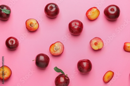 Fresh ripe plums on color background