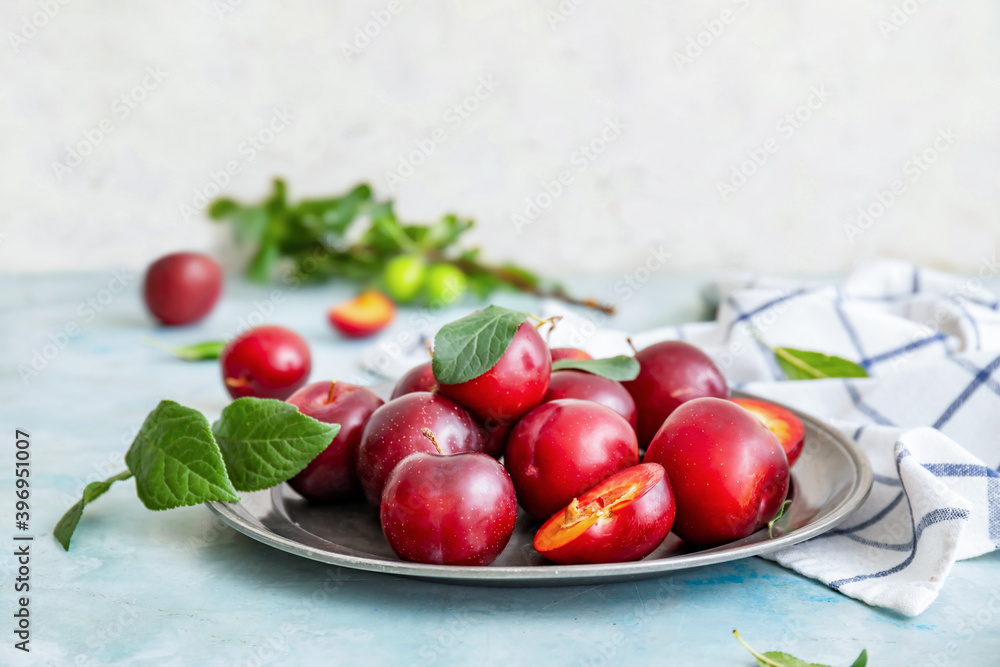 Plate with fresh ripe plums on table Plate with fresh ripe plums on table