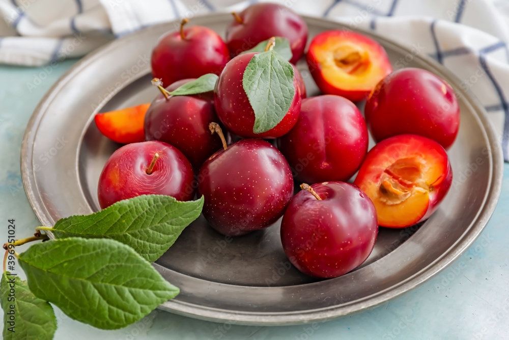 Plate with fresh ripe plums on table Plate with fresh ripe plums on table