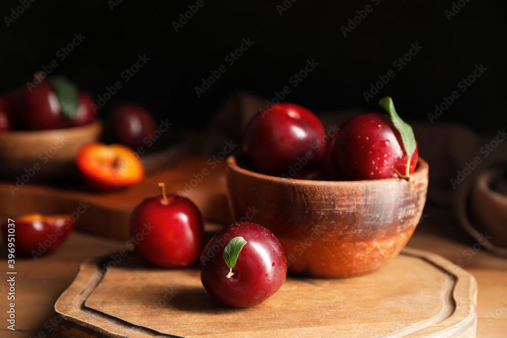 Bowl with fresh ripe plums on wooden table Bowl with fresh ripe plums on wooden table