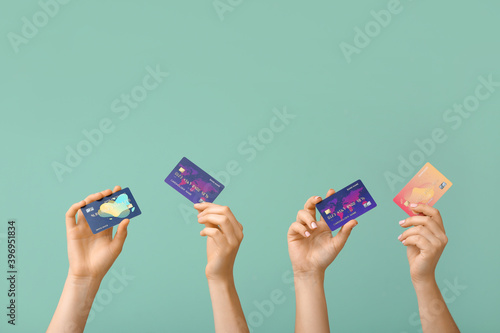 Female hands with credit cards on color background photo
