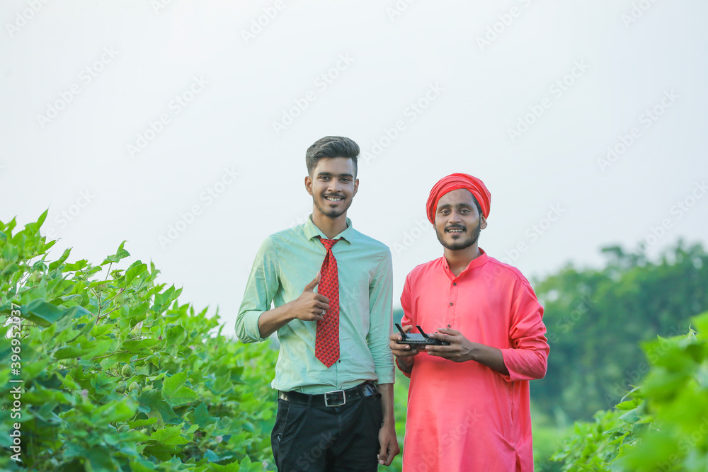 Young indian farmer and agronomist showing thumps up at agriculture field