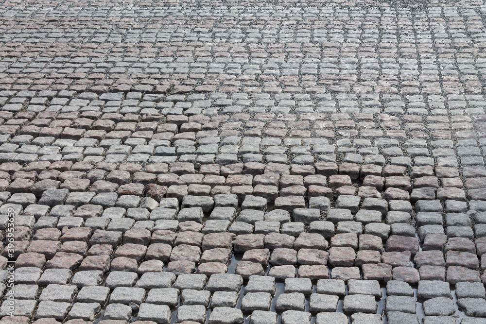The pavement is made of small cobblestones in the form of square tiles. Texture background