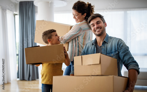 Happy young family unpacking cardboard boxes at new home © NDABCREATIVITY