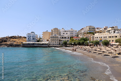 Rows of umbrellas on the beach of Agios Nikolaos in Crete, Greece