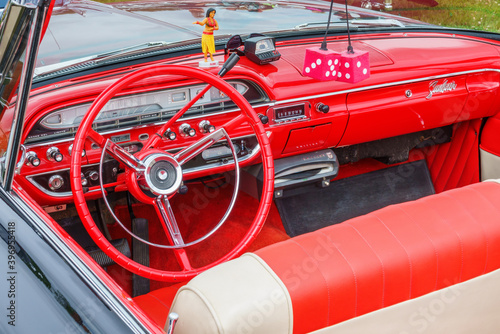 Red dashboard on an American classic car with fuzzy dice