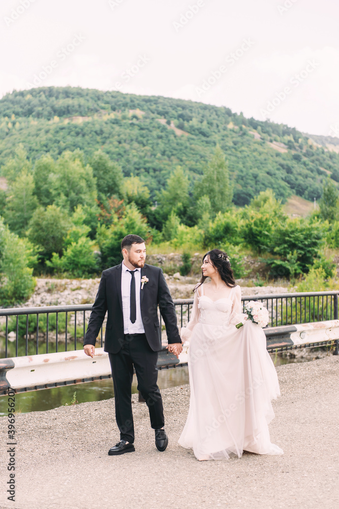 Walk the newlyweds in nature against the backdrop of wooded mountains Walk the newlyweds in nature against the backdrop of wooded mountains