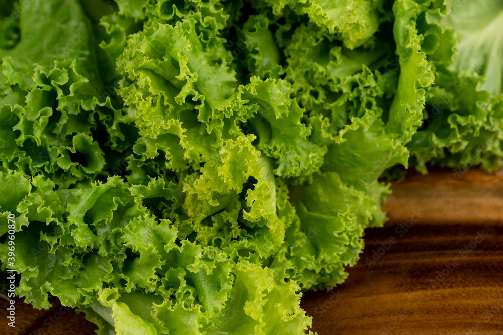 Green lettuce leaves lush with water drop on leaf on chopper board Green lettuce leaves lush with water drop on leaf on chopper board