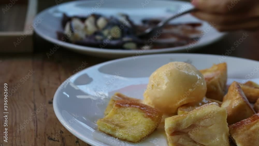 An ice cream with breads and another dessert on wooden table. An ice cream with breads and another dessert on wooden table.