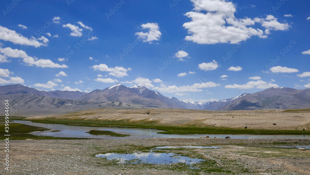 High-altitude mountain landscape with blue river at kyrgyz Alichur village on the Pamir Highway, Murghab district, in the Gorno-Badakshan region of Tajikistan