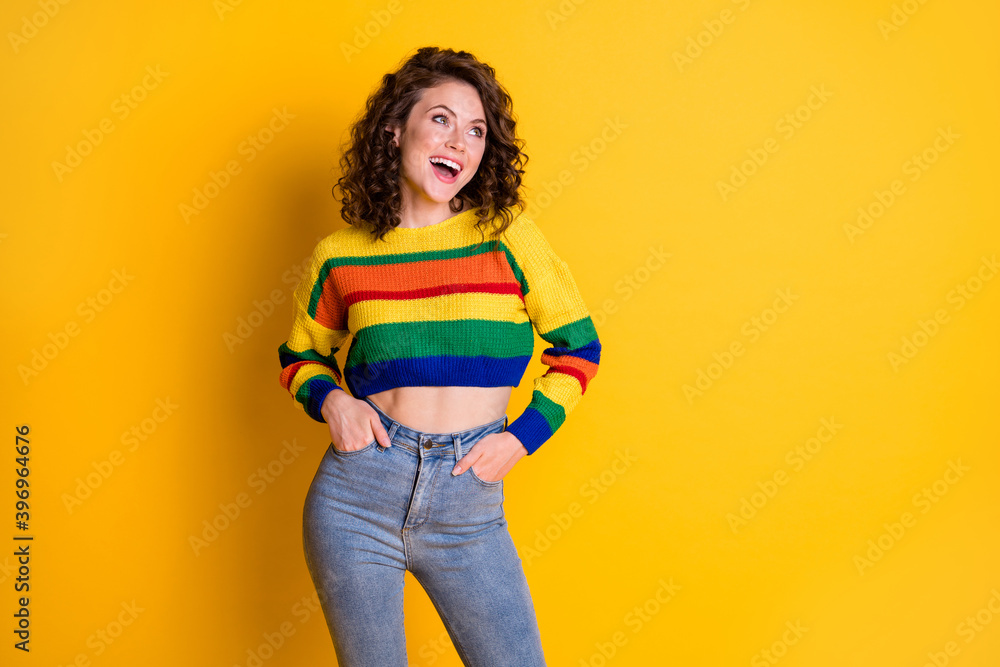 Photo portrait of laughing girl with two hands in pockets isolated on vivid yellow colored background Photo portrait of laughing girl with two hands in pockets isolated on vivid yellow colored background