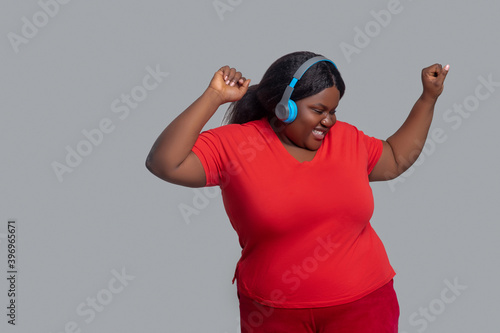 Canvastavla Young dark-skinned woman with headphones feeling energized