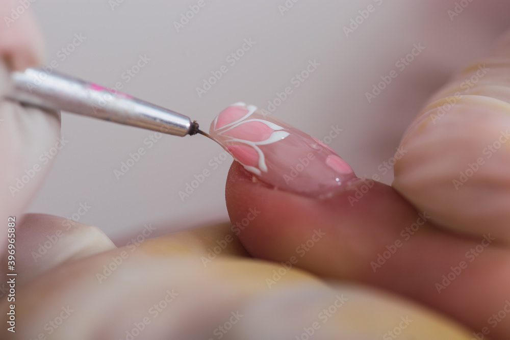 Closeup of brush painting nails. Manicurist working on a woman's nails. Closeup of brush painting nails. Manicurist working on a woman's nails.