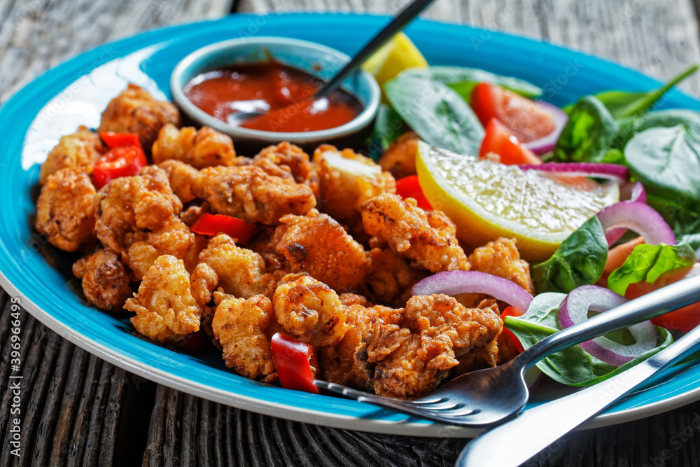 Popcorn chicken with ketchup and salad, close-up