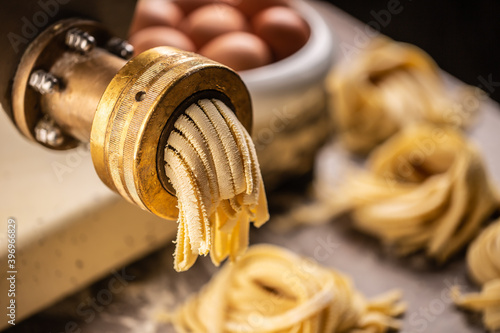 Fresh fettuccine pasta getting out of the pasta making machine