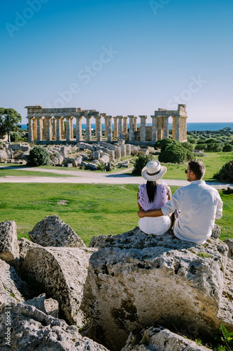 A couple visit Greek temples at Selinunte during vacation, View on sea and ruins of greek columns in Selinunte Archaeological Park Sicily Italy photo