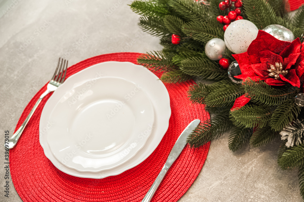 New Year's decor of modern kitchen in Scandinavian style. Serving a white plate on a red rustic napkin with a close-up and copy space. Hygge kitchen details New year concept. Selective focus New Year's decor of modern kitchen in Scandinavian style. Serving a white plate on a red rustic napkin with a close-up and copy space. Hygge kitchen details New year concept. Selective focus
