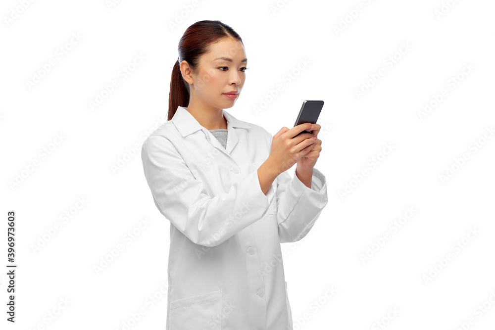 medicine, technology and healthcare concept - asian female doctor or scientist with stethoscope using smartphone over white background medicine, technology and healthcare concept - asian female doctor or scientist with stethoscope using smartphone over white background