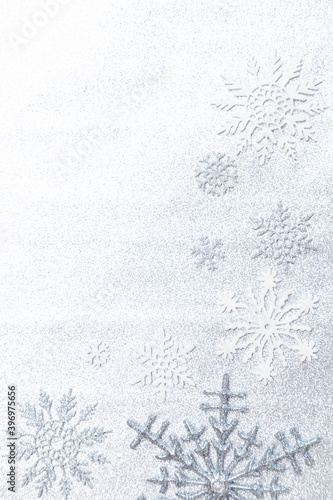Winter background image of silvery snowflakes on a silvery background.