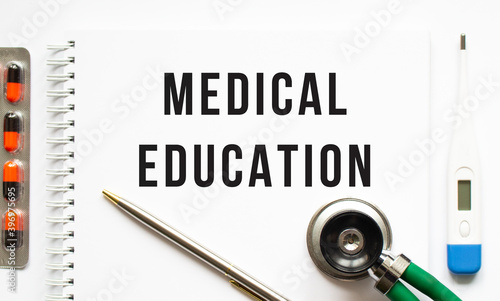 Wallpaper Mural MEDICAL EDUCATION is written in a notebook on a white table next to pills and a stethoscope. Torontodigital.ca