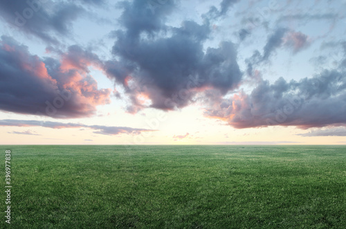 Image of green grass field and cloudy sky