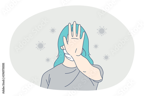 Danger or coronavirus infection epidemic, protective facial mask, pandemic concept. Young woman with blue hair in medical mask standing and showing protest sign with hand in corona bacteria flow