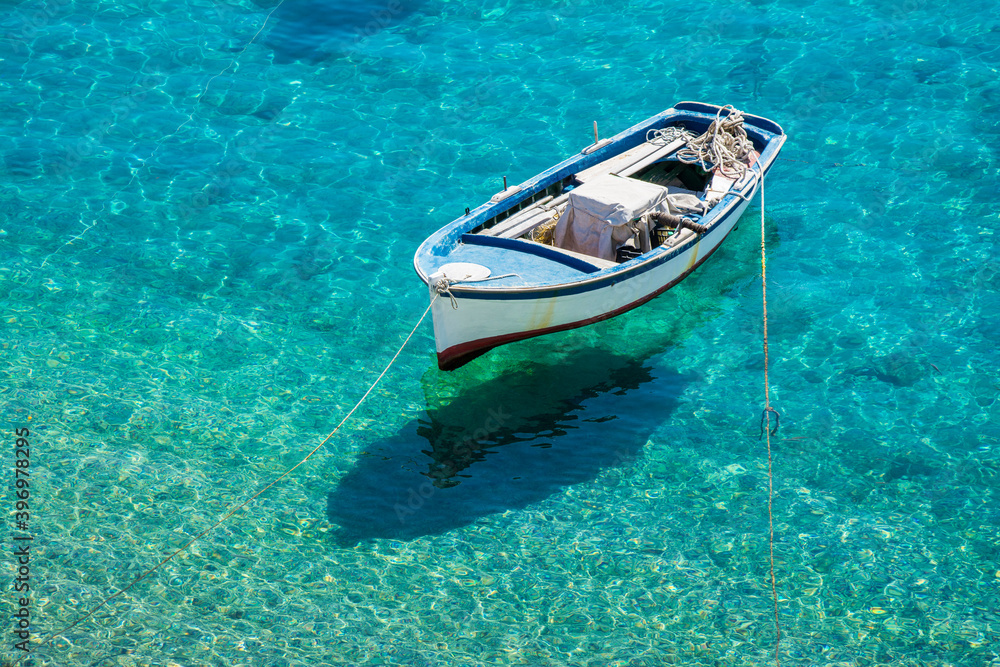 A fishing boat on the sea and Its shadow seen at the bottom easily in Kokkari village.