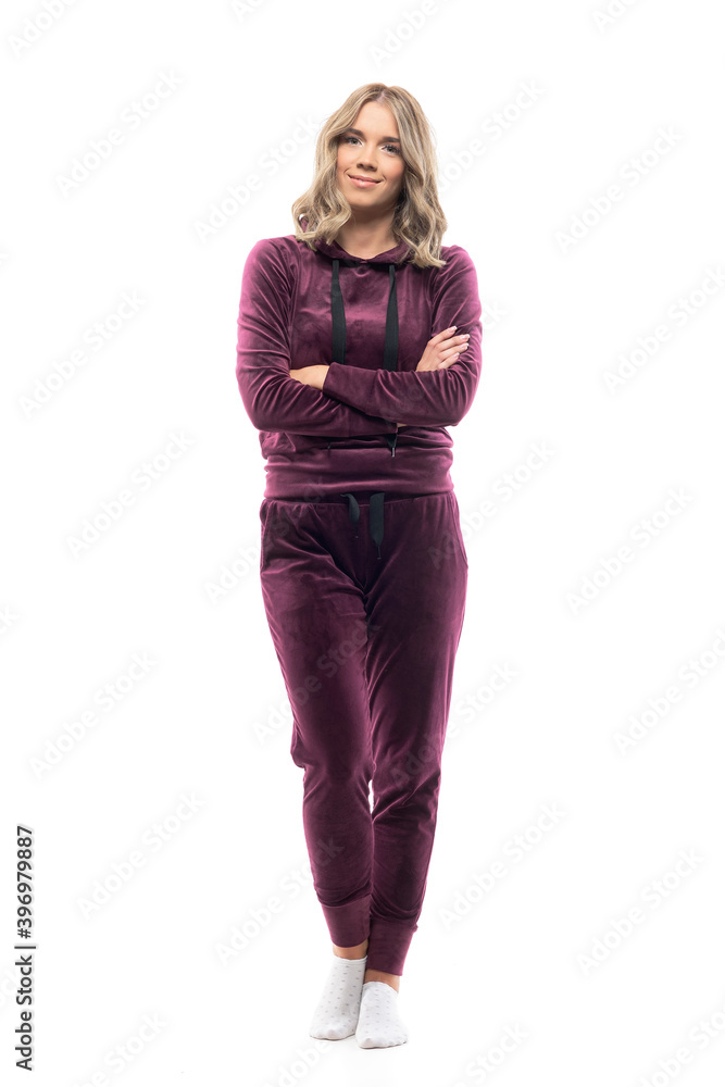 Peaceful relaxed confident young woman in comfy home wear sweatsuit smiling with crossed arms. Full body length isolated on white background. Peaceful relaxed confident young woman in comfy home wear sweatsuit smiling with crossed arms. Full body length isolated on white background.