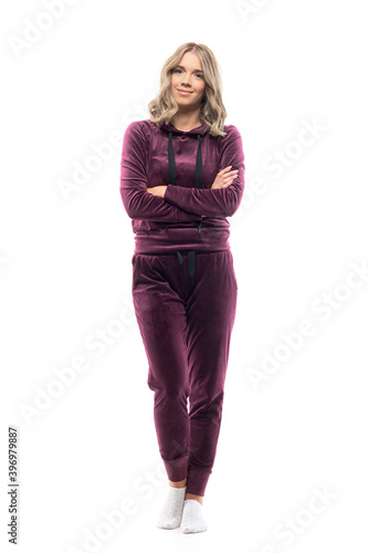 Peaceful relaxed confident young woman in comfy home wear sweatsuit smiling with crossed arms. Full body length isolated on white background. 