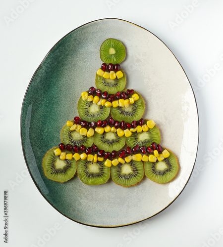 Christmas tree made with kiwi pomegranate and corn as decoration