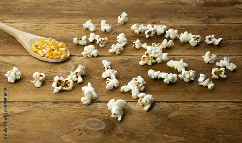 Corn seeds and popcorn on wooden background