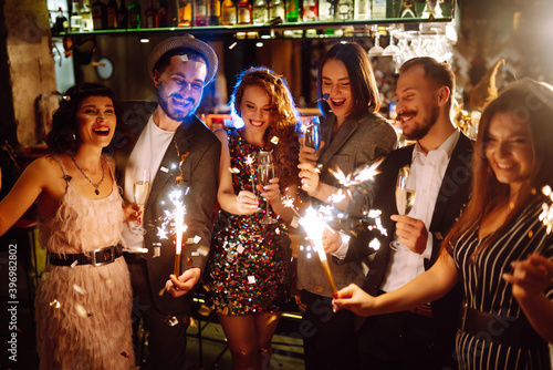 Photography Friends celebrate Christmas or New Years party with sparklers and champagne