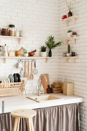 Rustic kitchen interior with white brick wall and white wooden shelves