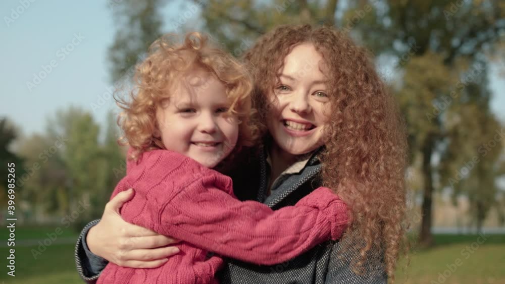 Beautiful red-haired mother holding adorable son, spending time together, fun Beautiful red-haired mother holding adorable son, spending time together, fun