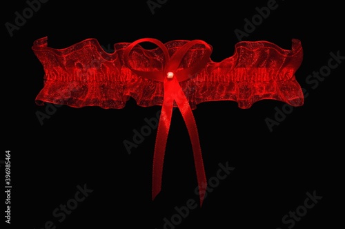 Red lace garter on a black background.