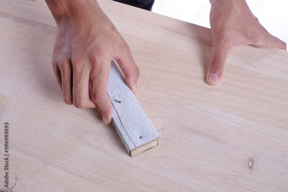 Young carpenter in work clothes using sandpaper for polishing sofa server project isolated on white background Young carpenter in work clothes using sandpaper for polishing sofa server project isolated on white background