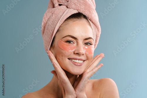Woman in towel taking care of her undereye area photo