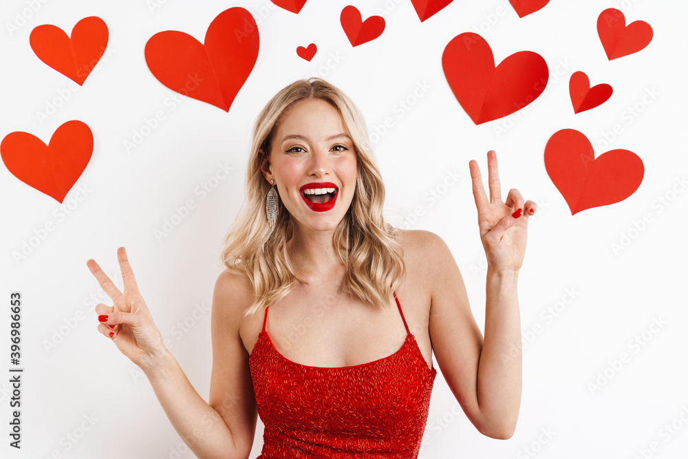 Positive blonde woman in red dress showing peace gesture Positive blonde woman in red dress showing peace gesture