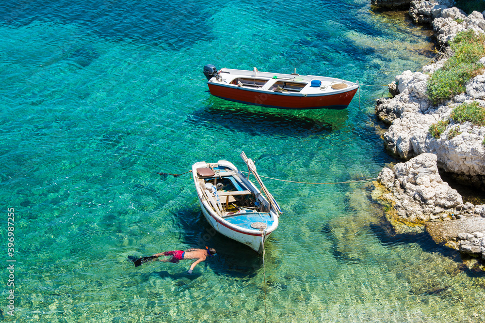 Obraz premium A fishing boat on the sea and Its shadow seen at the bottom easily in Kokkari village.