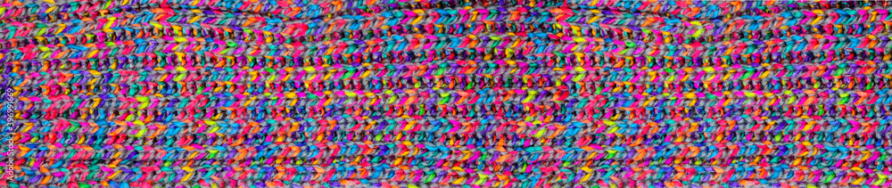 Detail of knitwear of a shawl. knitted fabric texture. Texture of mulicolored knit scarf. Large knitting. panoramic web banner Top view