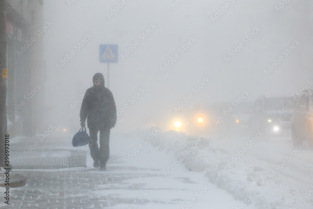 January, 2016 - Vladivostok, Russia - Heavy snowfall in Vladivostok. People walk along the central streets of Vladivostok covered with snow. Pedestrians walk past large snowdrifts through the city