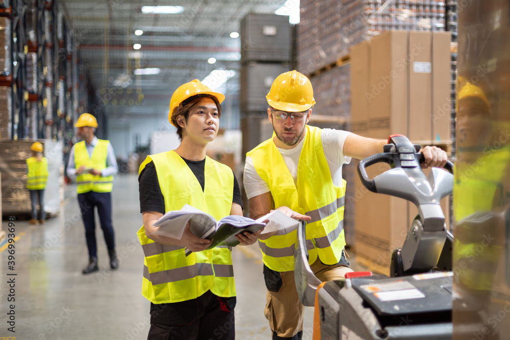 Employees consult while working in the warehouse Employees consult while working in the warehouse