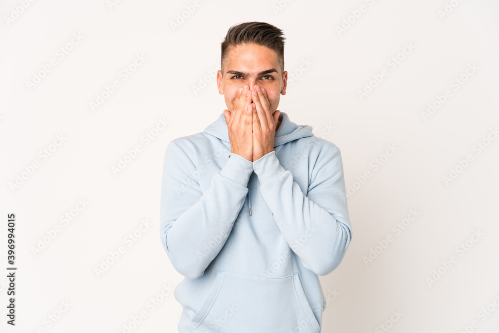 Young caucasian handsome man isolated laughing about something, covering mouth with hands.