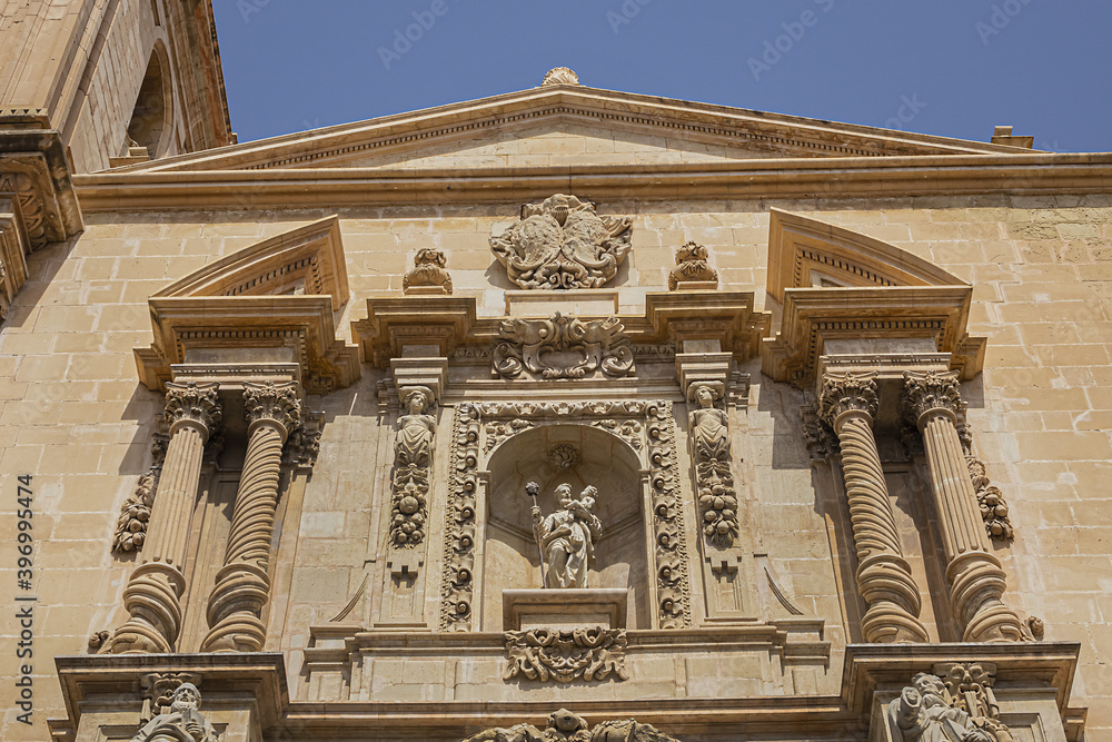Fototapeta premium Elche Santa Maria Basilica (XVII century) at Plaza de Santa Maria is built on the foundations of old mosque. Architectural fragments of Venetian baroque facade of Santa Maria Basilica. Elche, Spain.