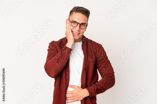 Young caucasian handsome man isolated laughs happily and has fun keeping hands on stomach.