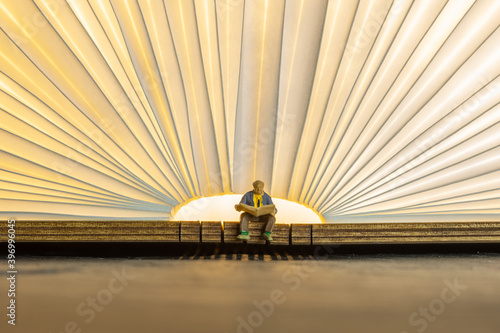 old man reading a book in front of a light