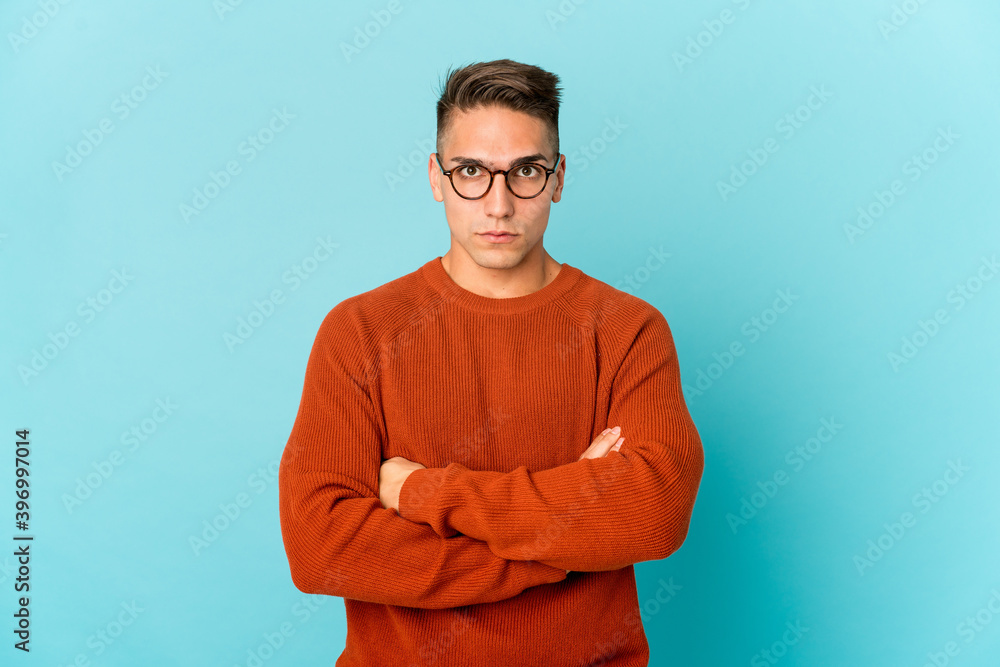 Young caucasian handsome man isolated blows cheeks, has tired expression. Facial expression concept.
