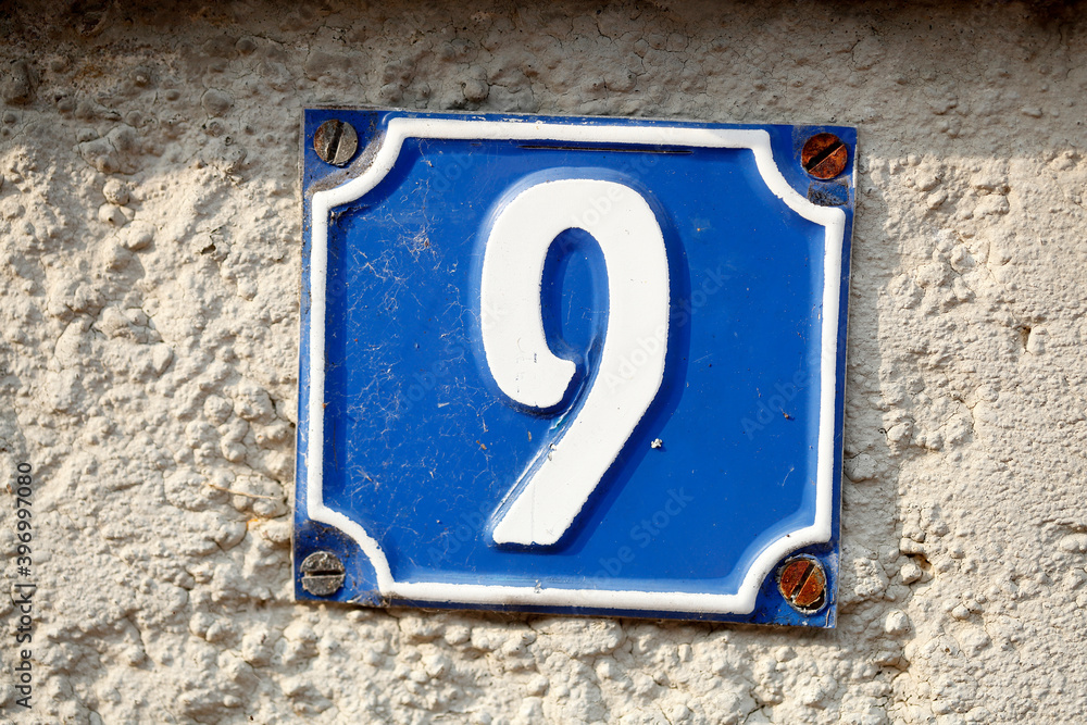 Blaues Hausnummernschild Nummer Neun auf weisser Hauswand, Deutschland, Europa Blaues Hausnummernschild Nummer Neun auf weisser Hauswand, Deutschland, Europa