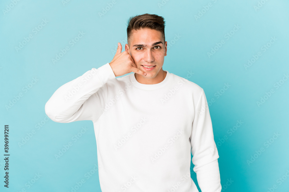 Young caucasian handsome man isolated showing a mobile phone call gesture with fingers. Young caucasian handsome man isolated showing a mobile phone call gesture with fingers.