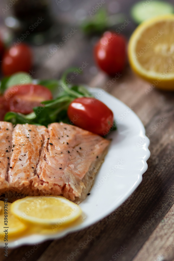 Salmon in a pan with lemon and other vegetables. Salmon on plates